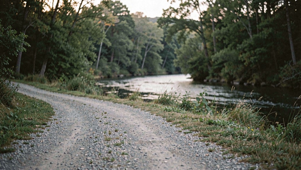 A clear river seam curling around dark stones beneath a soft morning sky, prepared for the fly fishing gear field note